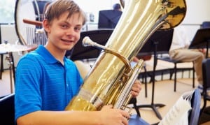 Male Pupil Playing Tuba In High School Orchestra